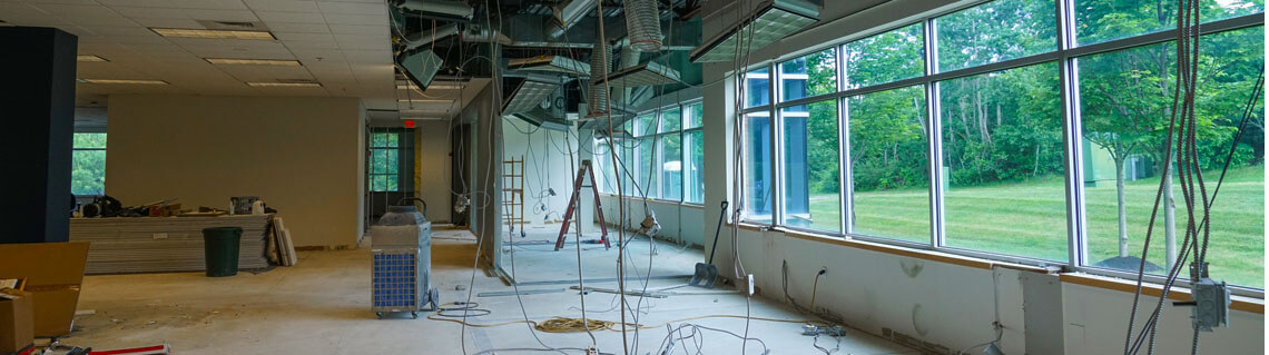 Interior view of a commercial renovation project with wires hanging down from the ceiling